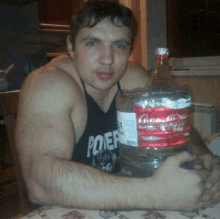 a man in a poer tank top holds a bottle of coca cola