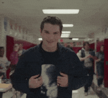 a young man is standing in a hallway wearing a t-shirt with a picture of a wolf on it .