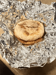 a muffin sandwich is wrapped in tin foil