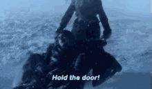 a woman is holding a dead man in the snow and saying `` hold the door ! ''