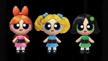 three dolls standing next to each other on a black background