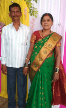 a man and a woman standing next to each other in front of a yellow curtain