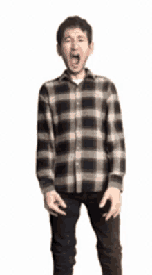 a man in a plaid shirt is standing with his mouth wide open