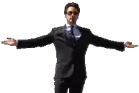 a man in a suit and tie stands with his arms outstretched