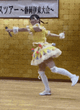 a girl in a yellow and white dress holds a microphone in front of a sign with chinese writing on it