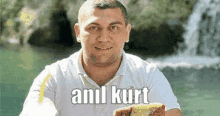 a man is holding a sandwich in front of a waterfall .