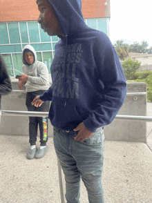 a man wearing a blue hoodie that says america rough ass on it