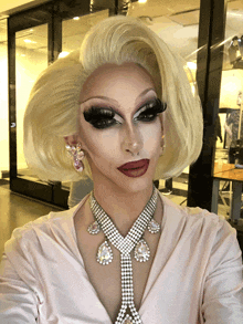 a drag queen wearing a necklace and earrings