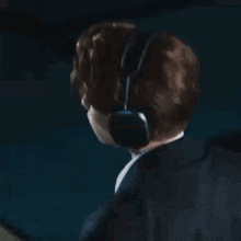 a man in a suit and tie is wearing headphones while dancing .