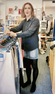 a woman standing in a store looking at clothes