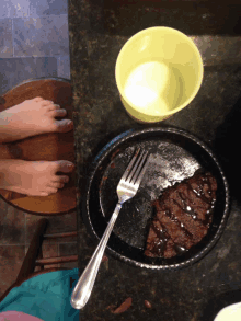 a plate of food with a fork and a cup of milk on a counter