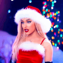 a woman is wearing a santa hat and a red dress .