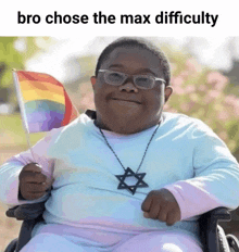 a man in a wheelchair holding a rainbow flag and a necklace with a star on it