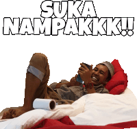 a man laying on a bed with a roll of toilet paper and the words suka nampakkk