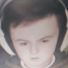 a boy wearing headphones looks at the camera