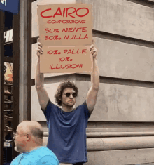 a man holding up a sign that says cairo