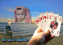 a hand holding a stack of playing cards with a picture of a child in the background