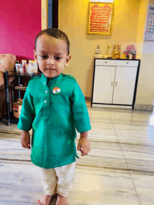 a little boy wearing a green shirt with an indian flag pin on it