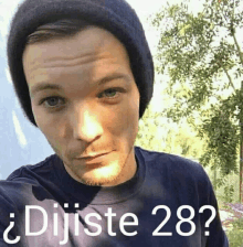 a man wearing a beanie and a blue shirt with the words dijiste 28