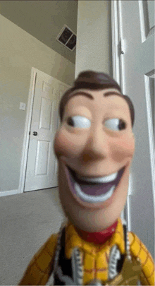 a toy story woody doll is smiling in front of a white door