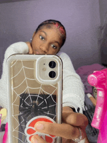 a girl taking a selfie with a clear phone case with a spider web design