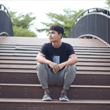 a man sits on a set of wooden stairs with his legs crossed