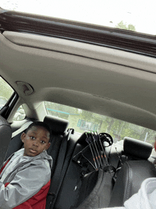 a young boy sitting in the back seat of a car