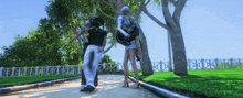 a man is carrying a woman in his arms on a path in a park