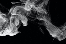 a black background with white smoke coming out of the bottom right corner