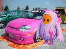 a pink car with flames painted on the front is next to a cartoon character