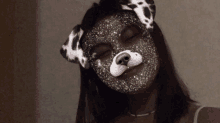 a girl wearing a dalmatian mask looks at the camera