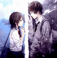 a boy and a girl are standing next to each other and touching each other 's faces .