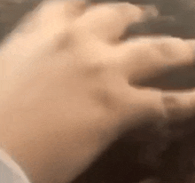 a close up of a person 's hand reaching out towards something .