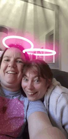 two women are posing for a selfie with pink circles on their heads