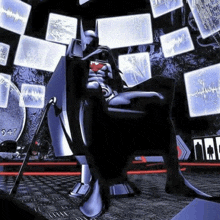 a man in a superhero costume is sitting in a chair in front of a bunch of monitors .