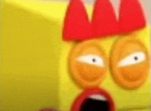 a close up of a cartoon character 's face with a red crown on it .