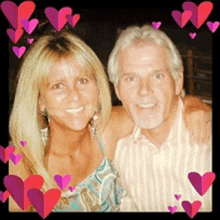 a man and a woman are posing for a picture with hearts in the background