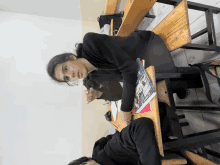 a girl sits at a desk with a book on it that says ' physics '