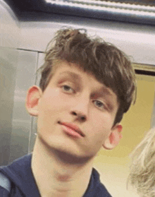 a close up of a young man 's face in an elevator looking at the camera .