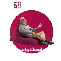 an elderly man sits on a bean bag chair with arabic writing on the bottom