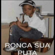 a young boy is giving a thumbs up while sitting in a chair with the caption ronca sua puta