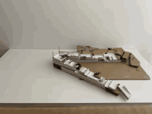 a cardboard model of a building is on a white table