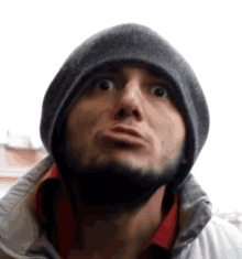 a man wearing a gray beanie and a red shirt makes a surprised face