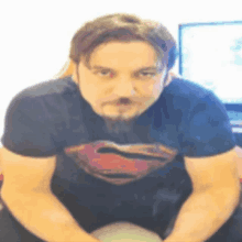 a man with a beard wearing a superman t-shirt