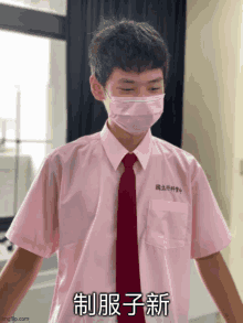 a young man wearing a pink shirt and red tie with chinese writing