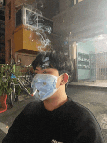 a man wearing a mask is smoking a cigarette outside