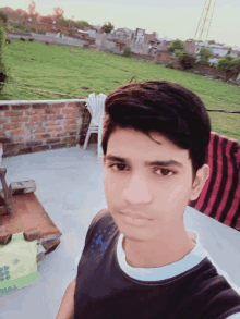 a young man taking a selfie in front of a field of grass