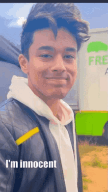 a young man standing in front of a truck that says free