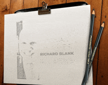 a drawing of richard blank is on a clipboard with two pencils