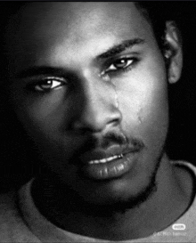 a black and white photo of a man crying with a tear coming out of his eye